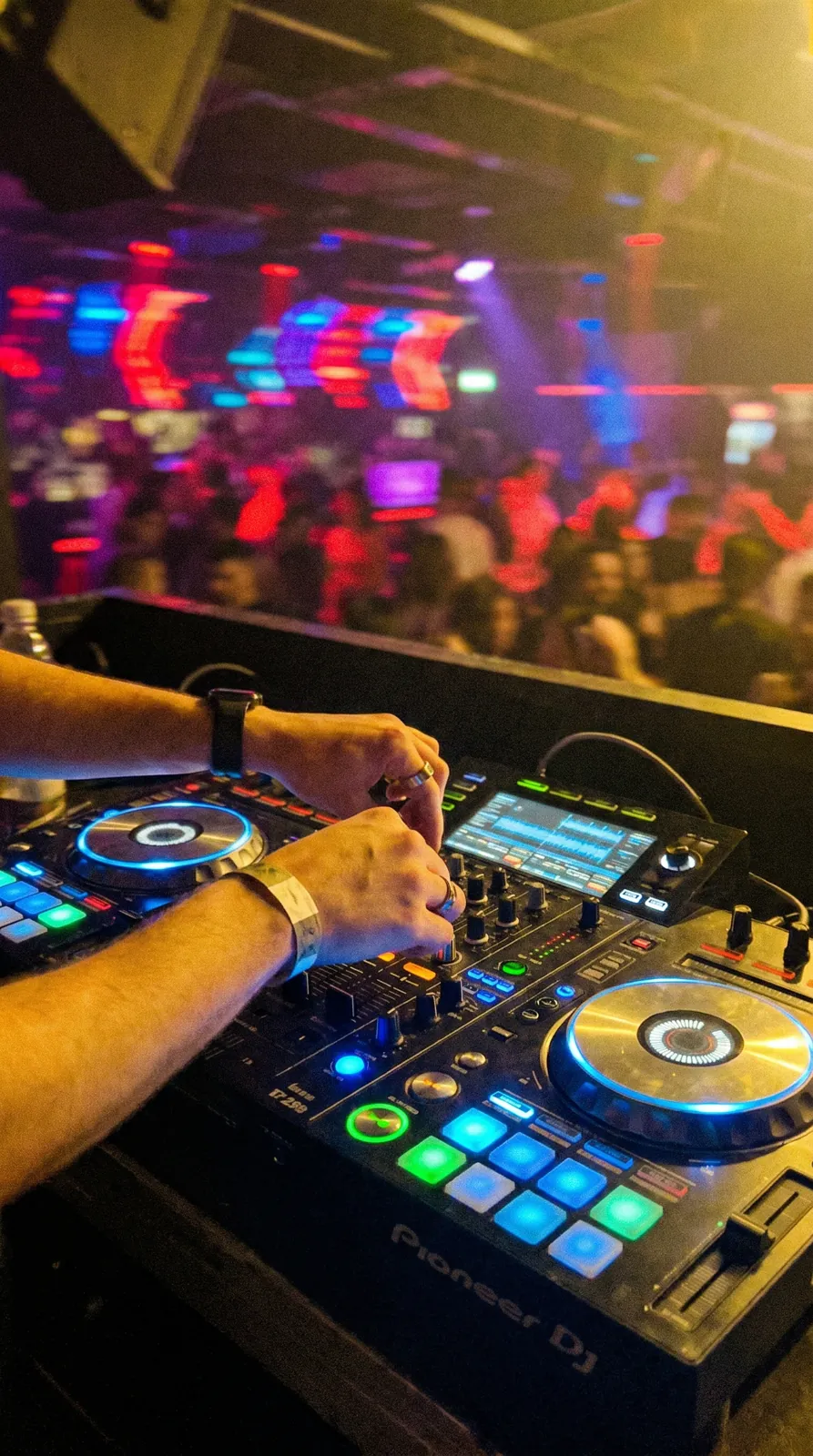 Close-up van de handen van een DJ achter de mixer