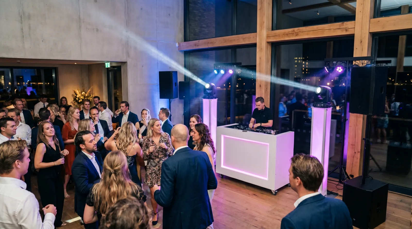 Feestende gasten onder blauwe verlichting bij de DJ