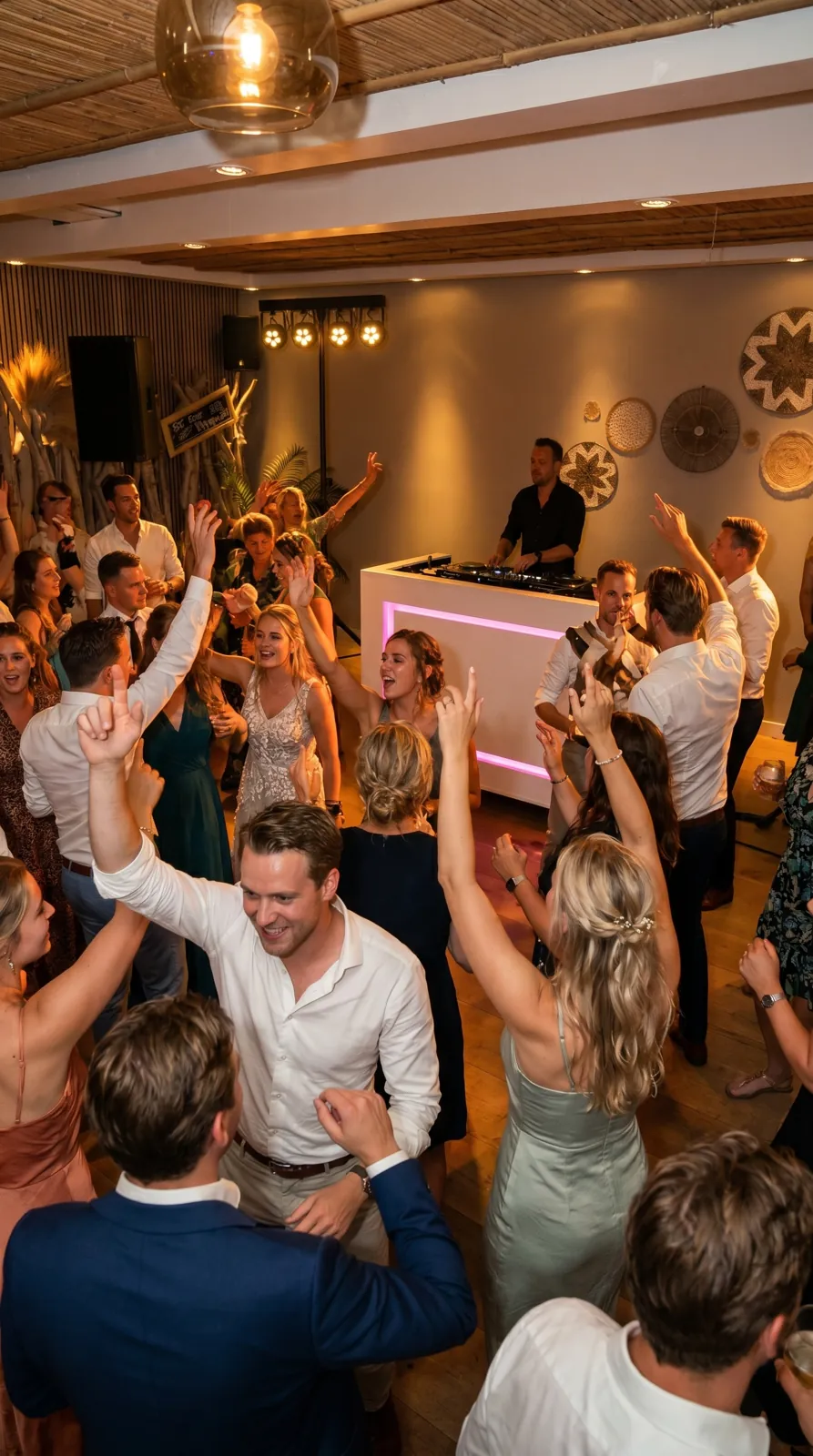 Feestende gasten rond een DJ-booth met roze verlichting